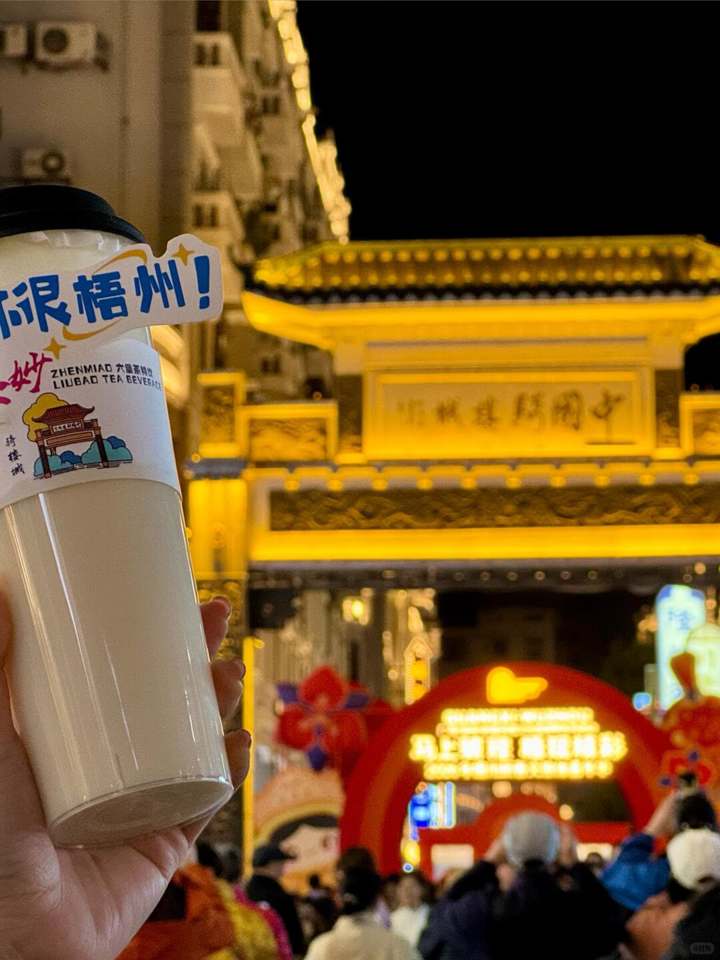 拿杯饮品在牌坊前拍一张